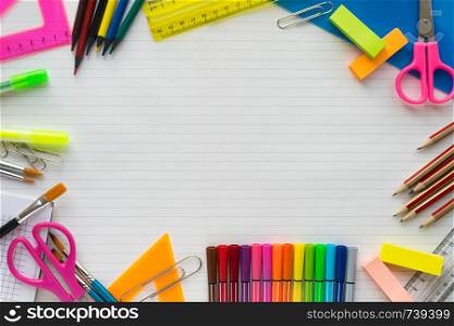 School supplies on sheet in a ruler background . Top view. Free space for text. School supplies on sheet in a ruler background . Top view