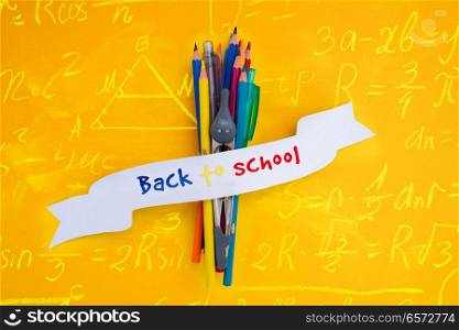 school supplies with back to school text on ribbon with math formulas. back to school