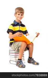 Schoolboy is sitting on books isolated on a white background. Back to school
