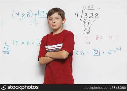 Schoolboy standing against whiteboard