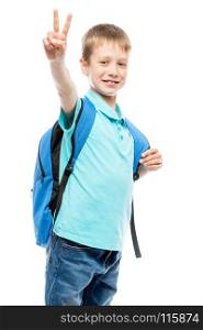 schoolboy with backpack smiling and showing a hand gesture on a white background isolated
