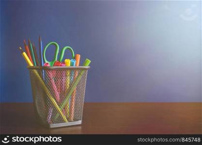 Schoolchild and student studies accessories. Back to school concept. Pencils and felt pens on blue backgroung. Copyspace. Toned. Schoolchild and student studies accessories. Back to school concept. Pencils and felt pens on blue backgroung with light rays. Toned. Copyspace