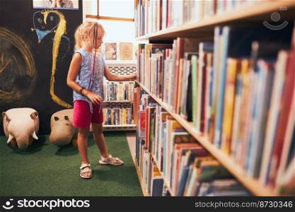 Schoolgirl looking for book for reading in school library. Student choosing literature for reading. Books on shelves in bookstore. Learning from books. Back to school. Elementary education. Doing homework