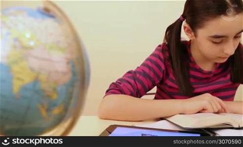 Schoolgirl reading and studying using digital tablet pc