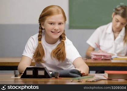 Schoolgirl sitting in a classroom and smiling