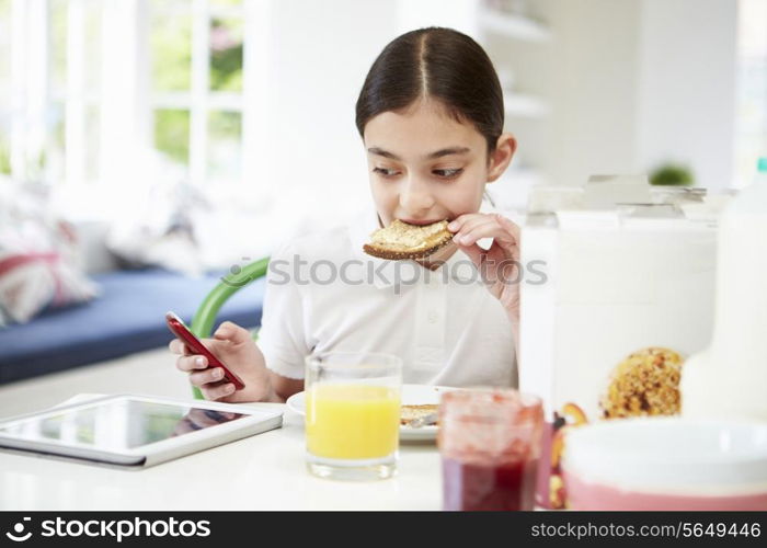 Schoolgirl With Digital Tablet And Mobile Eating Toast