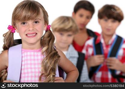 schoolgirl with satchel and boys in background
