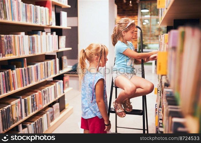 Schoolgirls looking for book for reading in school library. Students choosing books. Elementary education. Doing homework. Learning from books. Back to school