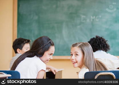 Schoolgirls talking in classroom