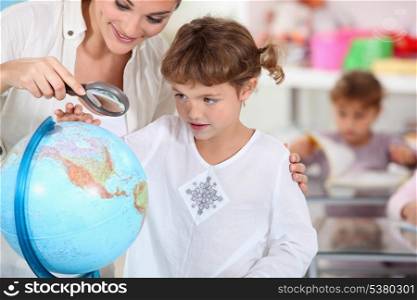 schoolmistress teaching geography with globe