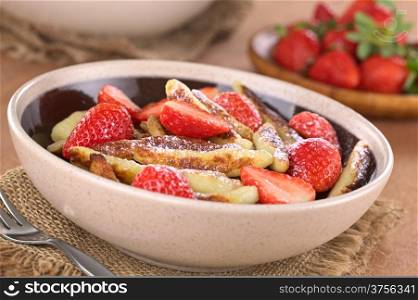 Schupfnudeln (Swabian potato noodles from Southern Germany) with fresh strawberries, cinnamon and sugar powder (Selective Focus, Focus on the front of the three strawberry pieces in the middle of the bowl)