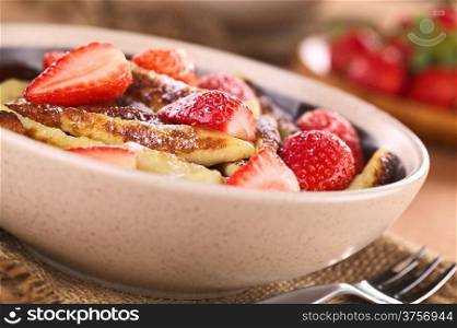 Schupfnudeln (Swabian potato noodles from Southern Germany) with fresh strawberries, cinnamon and sugar powder (Selective Focus, Focus on the front of the strawberry in the middle of the image and the noodle below it)