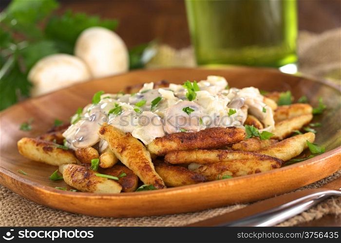 Schupfnudeln (Swabian potato noodles from Southern Germany) with mushroom sauce (Selective Focus, Focus on the front of the mushroom sauce)