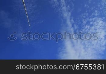 Schwenk von rechts nach links nber eine Windkraftanlage die vor blauem Himmel mit wei?en Wolken dreht.