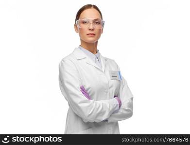 science and profession concept - female scientist in goggles and gloves with nametag on lab coat. female scientist in goggles and gloves