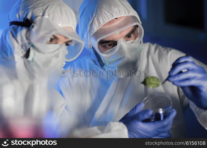 science, biology and people concept - close up of scientists hand with green leaf sample making research in clinical laboratory