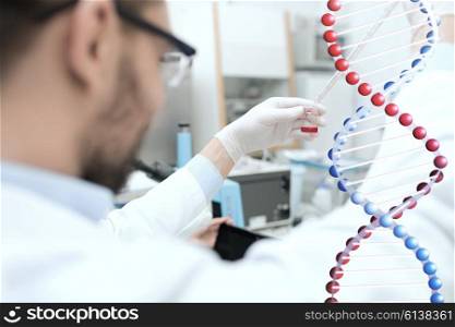 science, chemistry, biology, medicine and people concept - close up of male scientist with test tube and pipette making research in clinical laboratory