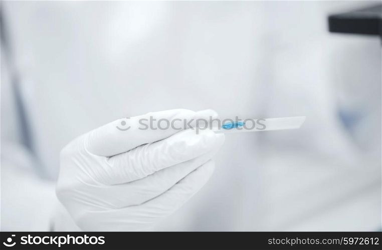 science, chemistry, biology, medicine and people concept - close up of scientist hand with test sample making research in clinical laboratory