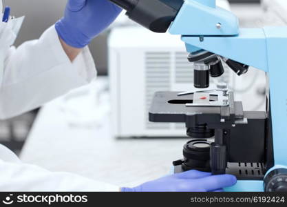 science, chemistry, biology, medicine and people concept - close up of scientist hands with microscope and blood test sample making research in clinical laboratory