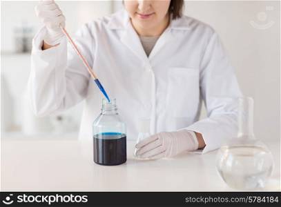 science, chemistry, biology, medicine and people concept - close up of young female scientist with pipette and flask making test or research in clinical laboratory