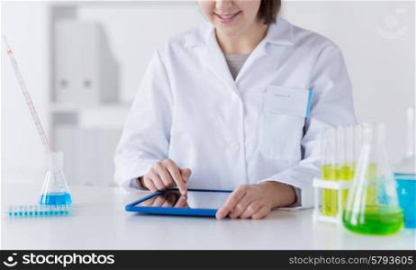 science, chemistry, biology, medicine and people concept - close up of young female scientist with tablet pc computer making test or research in clinical laboratory