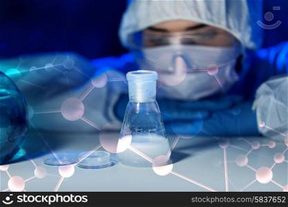 science, chemistry, biology, medicine and people concept - close up of young female scientist with chemical and flask making test or research in clinical laboratory