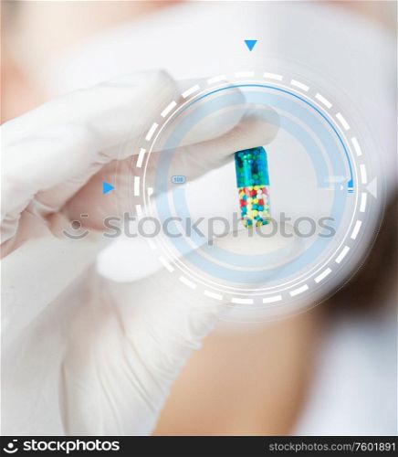 science, chemistry, biology, medicine and people concept - close up of young female scientist or doctor holding and showing pill in laboratory. close up of scientist holding pill in lab