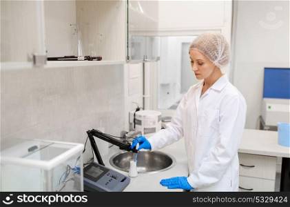 science, chemistry, industry and people concept - woman scientist or chemist with flask and sensor making test at laboratory. scientist with flask making test at laboratory