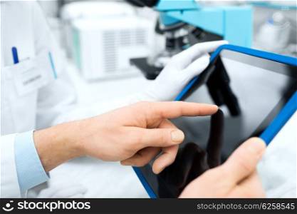 science, chemistry, technology, biology and people concept - close up of scientists hands with tablet pc in lab