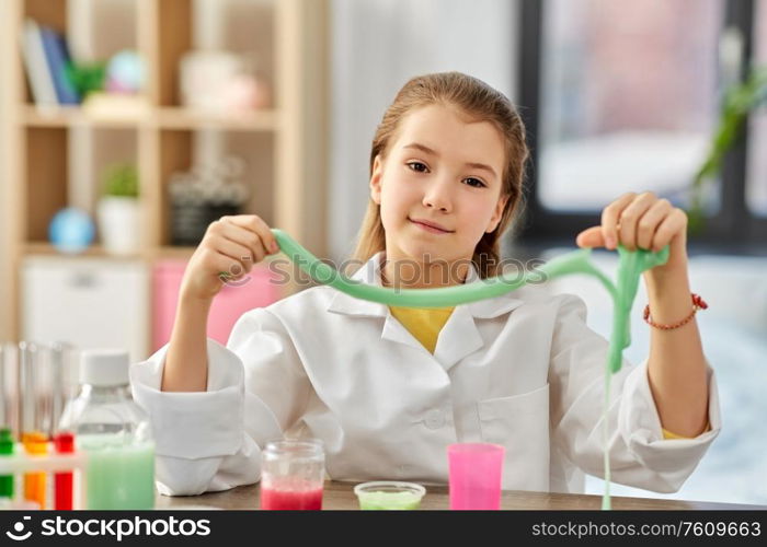 science, childhood and chemistry concept - girl playing with slime at home laboratory. girl playing with slime at home laboratory