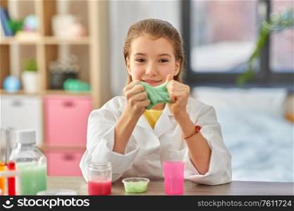 science, childhood and chemistry concept - girl playing with slime at home laboratory. girl playing with slime at home laboratory