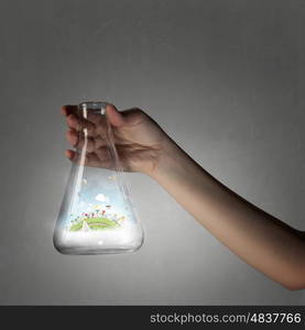 Science for green healthy life. Hand holds flask with image of green life concept