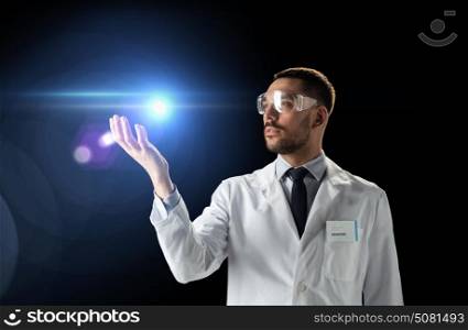 science, future technology and people concept - male doctor or scientist in white lab coat and safety glasses with laser light over black background. scientist in lab coat and goggles with laser light