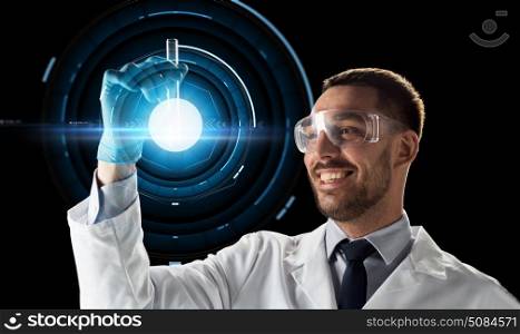 science, future technology and people concept - young smiling scientist in goggles with test tube and virtual projection over black background. smiling scientist in goggles with test tube. smiling scientist in goggles with test tube