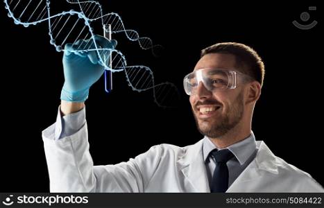 science, genetics and people concept - young smiling scientist in safety glasses with test tube and dna molecule projection over black background. smiling scientist in safety glasses with test tube. smiling scientist in safety glasses with test tube