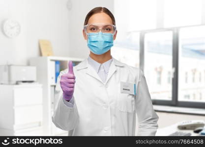 science, health and medicine concept - young female scientist wearing goggles and face protective medical mask for protection from virus over laboratory background. female scientist in medical mask and goggles