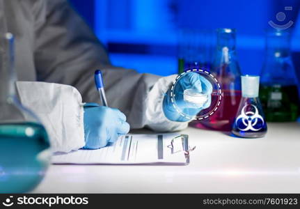 science, medicine and pandemic concept - close up of scientist with anti virus vaccine sample writing report of biohazard at scientific laboratory table with test tubes and. scientist with tests writing report of biohazard