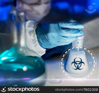 science, medicine and pandemic concept - close up of scientist with biohazard sign on flask making test or research in clinical laboratory. close up of scientist making test in lab