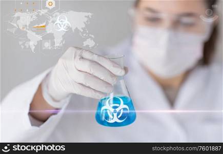 science, medicine and pandemic concept - close up of young female scientist holding test tune with biohazard caution sign over wold map. scientist holding test tube with biohazard symbol