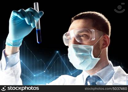 science, medicine, chemistry, research and people concept - young scientist in safety glasses and face mask with test tube and virtual charts projection. scientist with safety glasses, mask and test tube