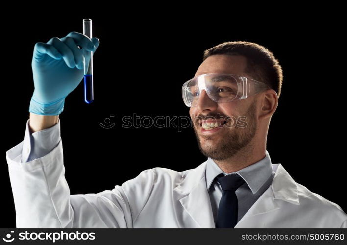 science, medicine, chemistry, research and people concept - young smiling scientist in safety glasses with test tube. smiling scientist in safety glasses with test tube
