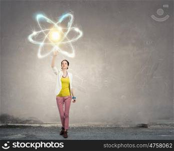 Science research concept. Teenager girl touching with palm atom molecule symbol