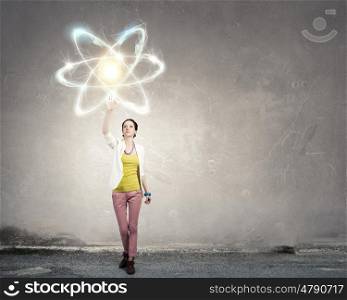 Science research concept. Teenager girl touching with palm atom molecule symbol