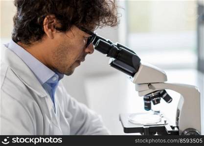 science research, work and people concept - close up of male scientist with microscope working in laboratory. scientist with microscope working in laboratory