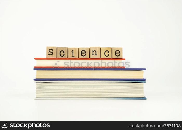 science word on wood stamps stack on books, knowledge and academic concept