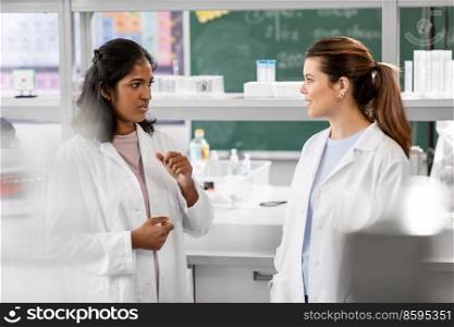 science, work and people concept - international female scientists talking in laboratory. international female scientists talk in laboratory