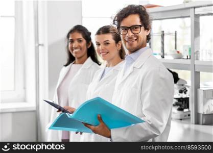 science, work and people concept - international group of happy scientists in laboratory. international group of scientists in laboratory