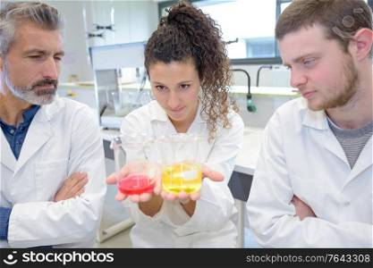 scientific researcher holding at a liquid solution in a lab