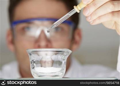 Scientist Adding Liquid To Glass Dish From Dropper