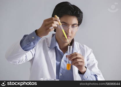 Scientist adding liquid to the test tube